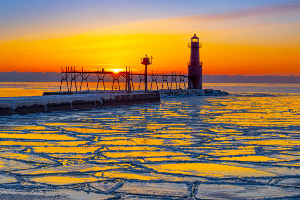 Amazing icy Winter scene in harbor by lighthouse