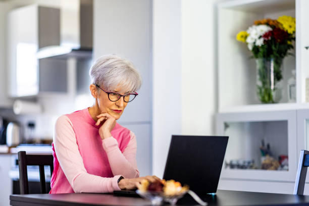 istock Senior woman working from home with laptop computer 1474869024