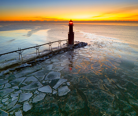 Amazing icy scenic harbor with lighthouse, Lake Michigan in Winter.