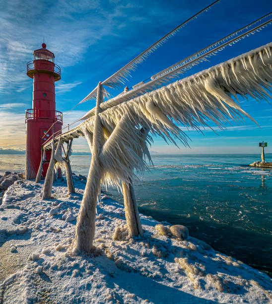 istock Amazing icy Winter scene in harbor by lighthouse 1474870258