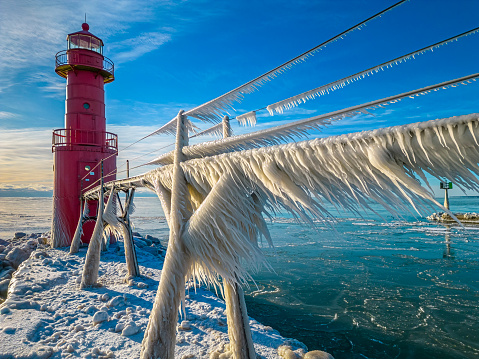 Amazing icy scenic harbor with lighthouse, Lake Michigan in Winter.