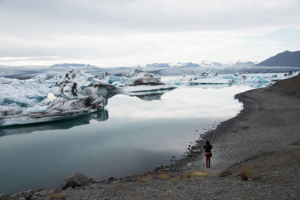 istock Woman seen from her back taking a picture at glacier 1474870639