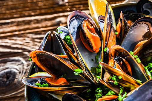 Composition with a plate of steamed mussels served with parsley and lemon