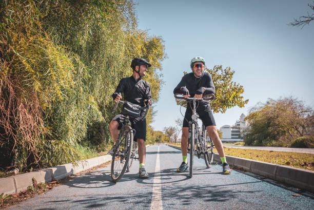istock Professional cyclist friends talking while resting on the bicycle lane 1474873976
