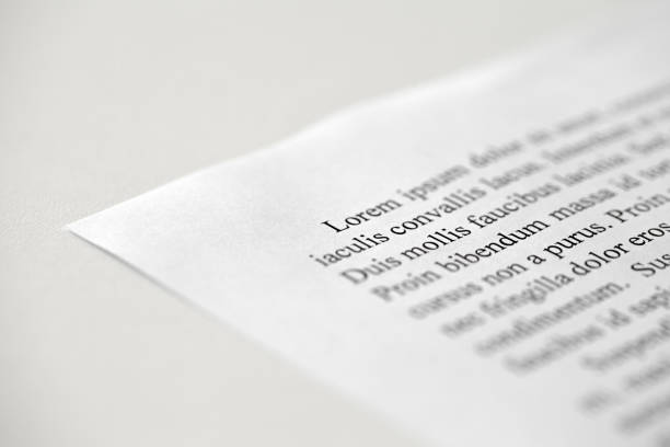 istock Lorem Ipsum dolor text on printed on paper in black and white, sample of document, side view, selective focus 1474874949