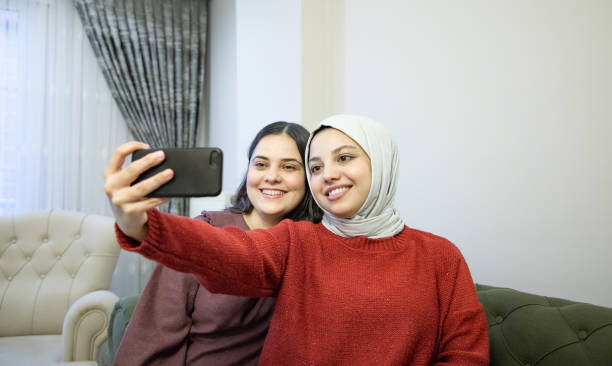 istock Two girlfriends taking selfie at home 1474876418
