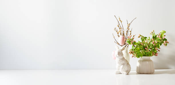 istock Spring flowers in a vase and easter bunny on a light background. Easter background with copy space 1474878816
