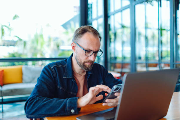 istock Adult man working from cafe using laptop, serious and concentrated 1474879115