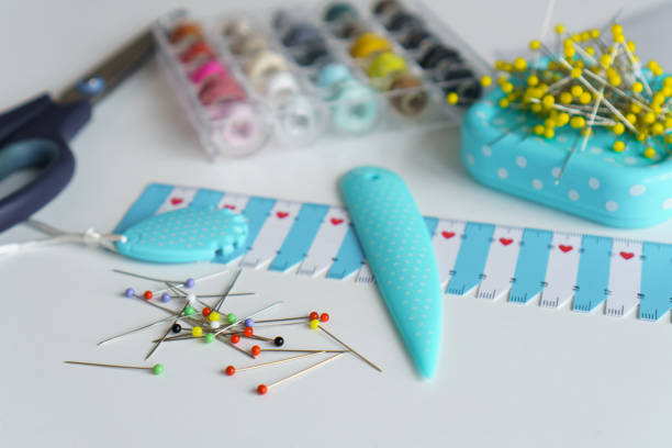 Sewing items. Tailoring scissors, measuring tape, spools of thread, seamstress tools, rulers, buttons, pins, needles and jersey knitted fabrics
