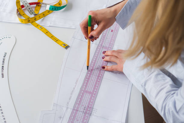 istock Female designer drawing paper patterns. Exclusive clothes making concept. Workplace of seamstress 1474881206