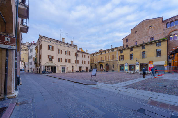 Mantua, Italy - February 27, 2023: View of the Piazza Broletto, with local monuments and businesses, locals, and visitors, in Mantua (Mantova), Lombardy, Northern Italy