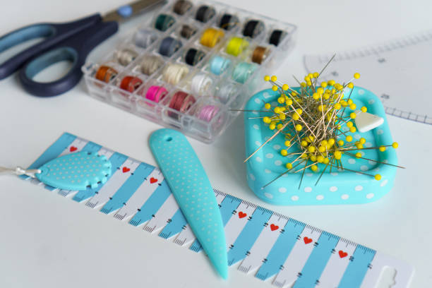 Sewing items. Tailoring scissors, measuring tape, spools of thread, seamstress tools, rulers, buttons, pins, needles and jersey knitted fabrics