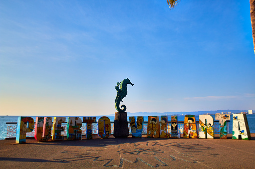Puerto Vallarta, Jalisco Mexico, February 18 2023 Letrero turistico de puerto vallarta jalisco durante la hora dorada y escultura de caballito de mar