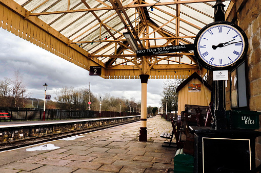 Hove, united kingdom - March 05 2022: a passenger is sitting and waiting for a train on a platform or a british train station