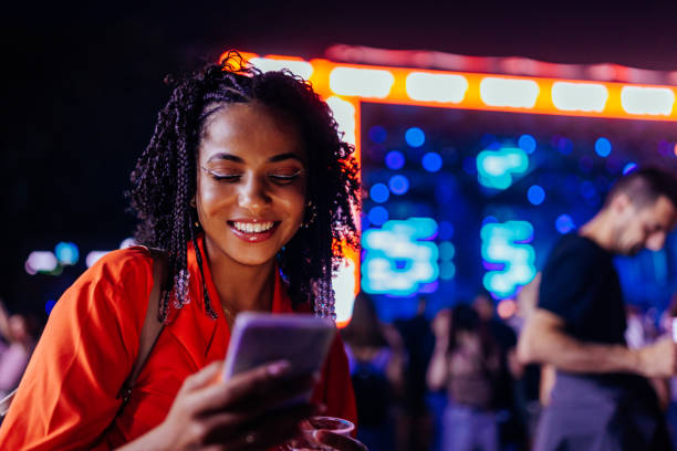 istock Smiling girl messaging at concert 1474885602