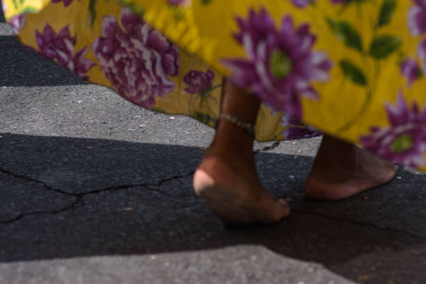 Details of feet walking on asphalt.\nCarnaval de Belo Horizonte
