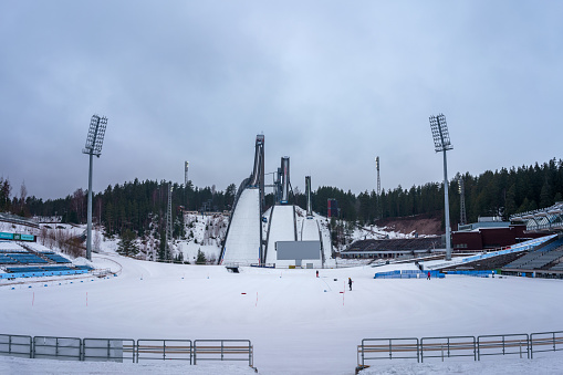 Ski jumper flying against the blue sky and the mountain