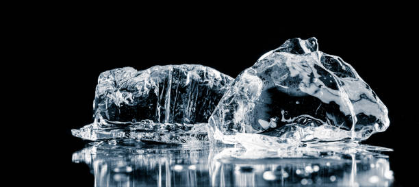 istock Natural textured ice cubes, melting on a black reflective surface. 1474888067