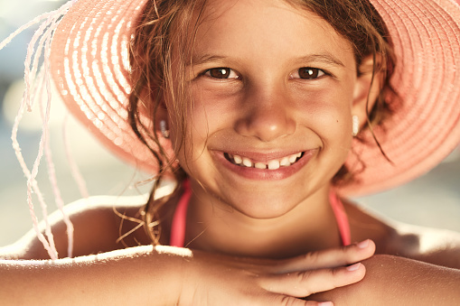 Beautiful girl enjoying seaside on a beautiful sunny day. She is happy, smiling, enjoying on the sand.