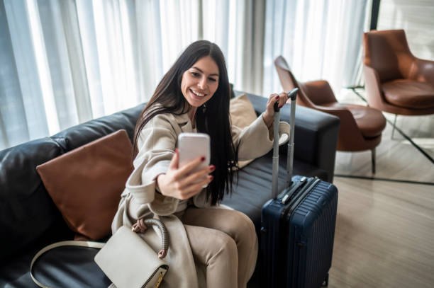 istock Smiling brunette seen taking selfie in the hotel lobby 1474893738