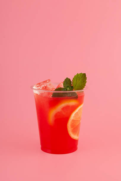 istock Red Fruit Sangria in disposable take away cup on pink background. Summer refreshing drink. Iced cocktail with natural juice and leaf mint 1474894692