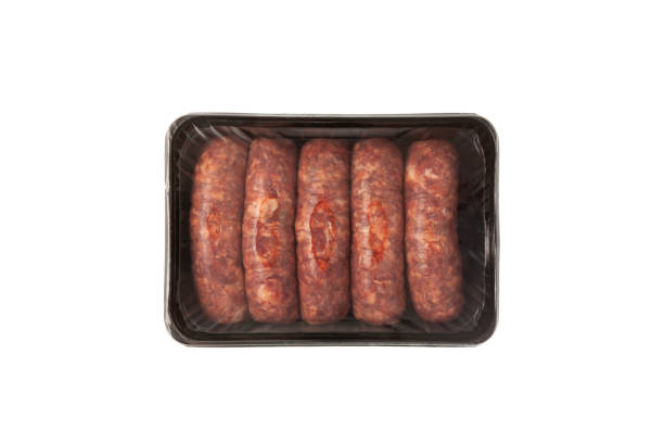 prodotti di salsicce da barbecue crudi in scatola di plastica usa e getta. frankfurters di manzo in confezione su sfondo bianco, vista dall'alto - sausage knackwurst food bratwurst foto e immagini stock