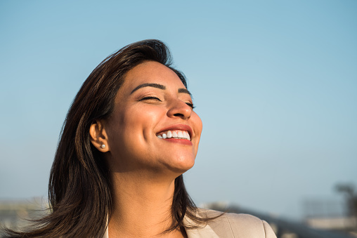 Latin woman smiles happily relaxed with her eyes closed. Copy space