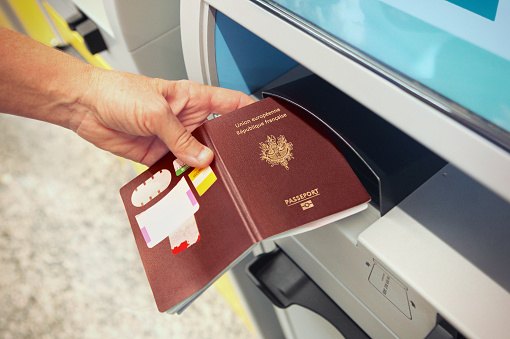 Passenger scanning french passport at online check-in counter at the airport