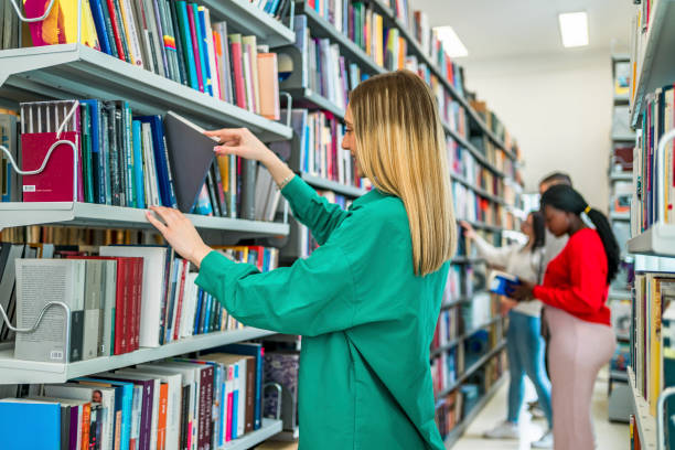 istock Young female student choosing a book in the library 1474897732