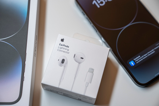 New iPhone 14 pro max and Apple Earpods, Airpods white earphones for listening to music and podcasts, in a closed box. Isolated white background. Budapest, Hungary - February 16, 2023