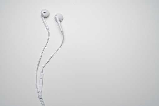 iPhone Apple Earpods, Airpods white earphones, headphones for listening to music and podcasts. Isolated white background. Budapest, Hungary - February 16, 2023