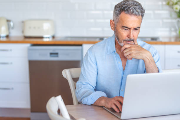istock Mature businessman working on a laptop at home. 1474901199