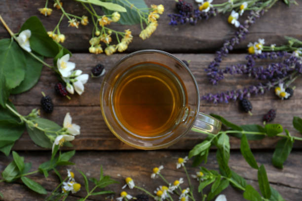 istock Cup of hot aromatic tea and different fresh herbs on wooden table, flat lay 1474901664