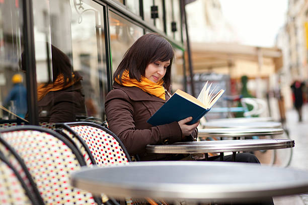 istock Beautiful young woman reading a book in cafe 147490320