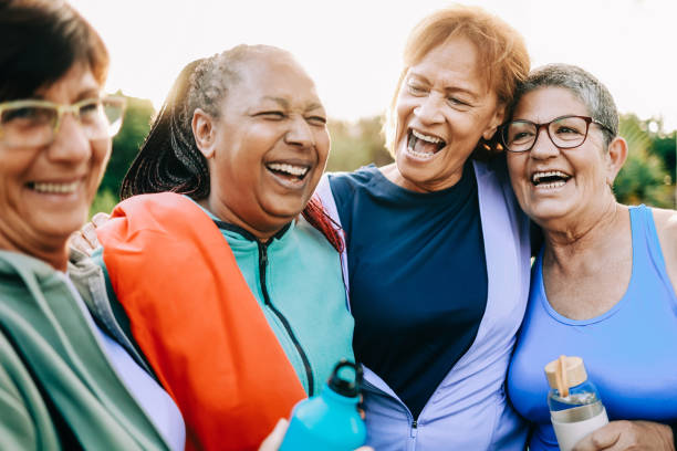 sport wielorasowy, seniorki bawiące się razem po treningu fizycznym na świeżym powietrzu w parku miejskim - senior adult relaxation exercise healthy lifestyle exercising zdjęcia i obrazy z banku zdjęć