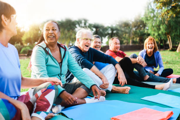 Happy senior people after yoga sport class having fun sitting outdoors in park city Happy senior people after yoga sport class having fun sitting outdoors in park city yoga class stock pictures, royalty-free photos & images