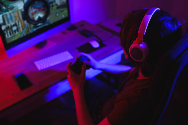 adolescente jogando jogos multiplayer no pc desktop em sua sala escura - mental illness audio - fotografias e filmes do acervo