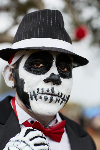 Oceanside, CA—10/30/2016: A man has his face painted for the Day of the Dead. The Day of the Dead is a traditional day of remembrance in the Mexican culture for those who have passed away. During this day, people visit the graves of relatives and leave gifts and flowers.