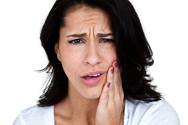 Woman with toothache Woman with toothache holding her jaw and isolated on white background  jaw pain stock pictures, royalty-free photos & images