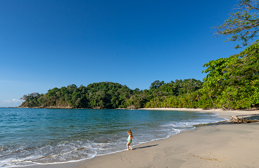 Toddler playing on Manuel Antonio Beach's wild untamed coast in Manuel Antonio National Park on the Pacific Coast of Costa Rica