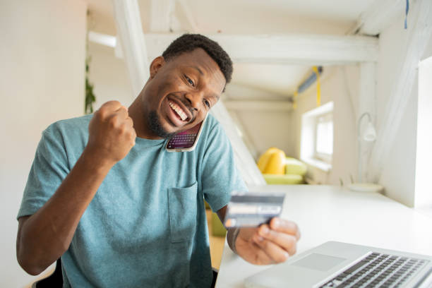 istock Cheerful man doing online shopping 1474919717