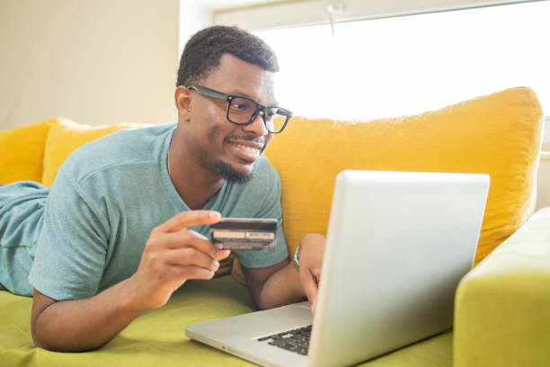 istock Cheerful man doing online shopping 1474919724