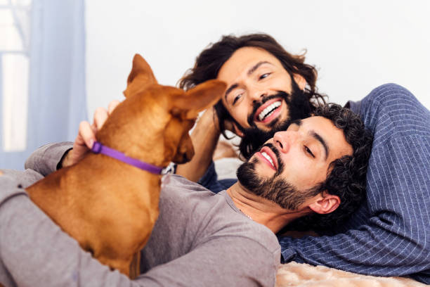 istock couple relaxing happy lying in bed with their dog 1474919877
