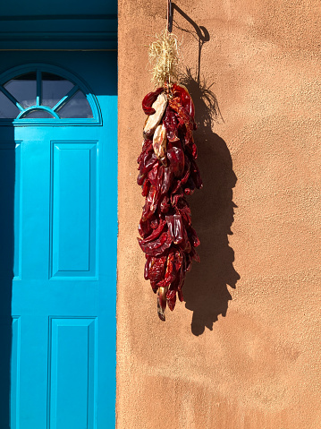 Santa Fe, NM: Sunlit Chili Pepper Ristra, Adobe Wall, Blue Door