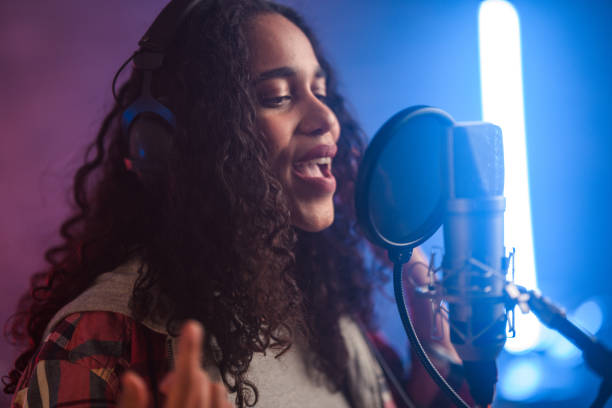 istock Young Hispanic Beautiful Woman Singing in Recording Studio 1474922937