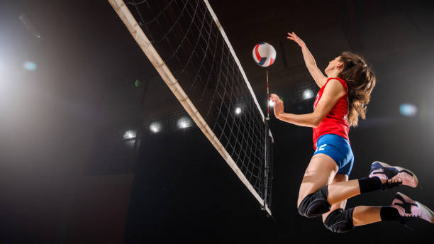 ネット越しにボールを蹴る女子バレーボール選手 - high jump 写真 ストックフォトと画像