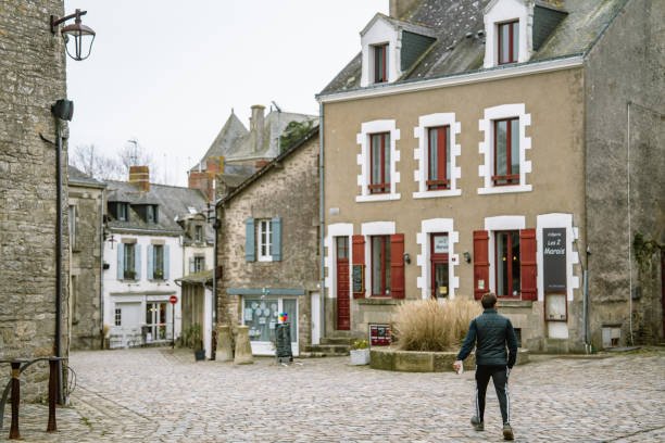 Guerande, Brittany,France,March 10th 2023: Young man walking in the medieval town of Guerande. Guerande is one the most iconic town in Brittany for its salt and architecture.