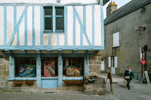 Guerande, Brittany,France,March 10th 2023: A senior woman walking in the medieval town of Guerande. Guerande is one the most iconic town in Brittany for its salt and architecture.
