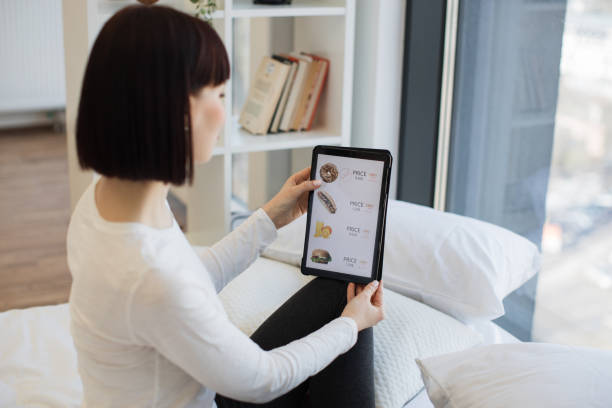 istock Woman ordering takeaway lunch with discount on tablet 1474931523