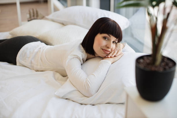 istock Woman relaxing on comfy bed during free time 1474931586